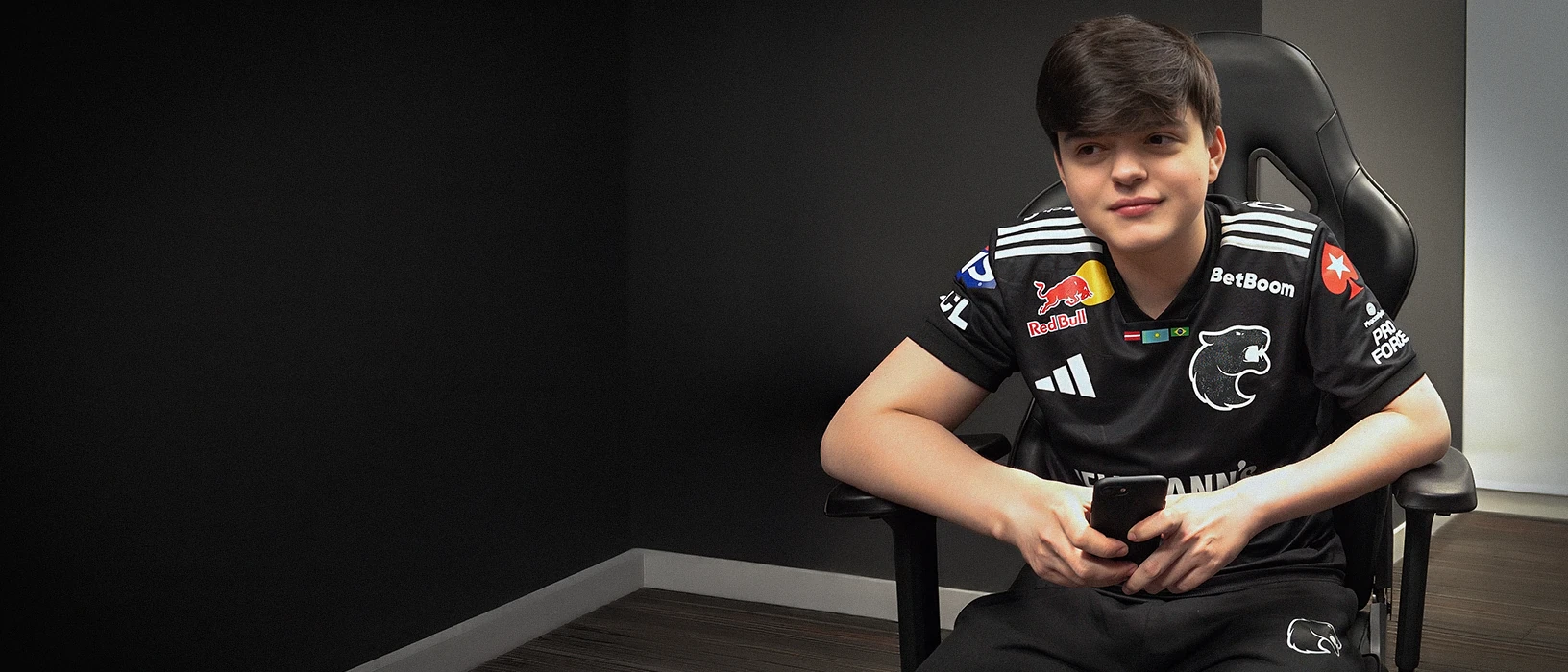 FURIA fan following matches on a phone in a dimly lit room